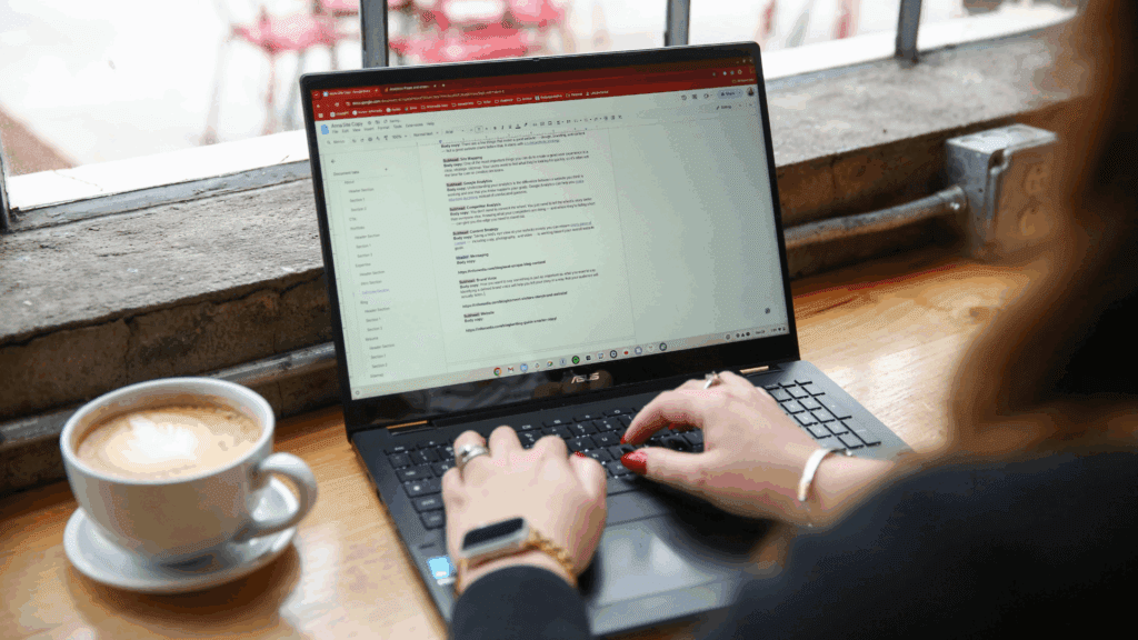 Laptop screen showing someone working on website copy with a latte on the left of the screen